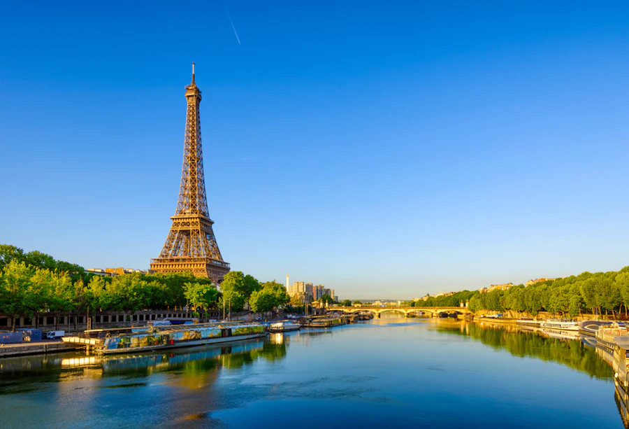 De Eiffeltoren naast de Seine onder een heldere blauwe lucht