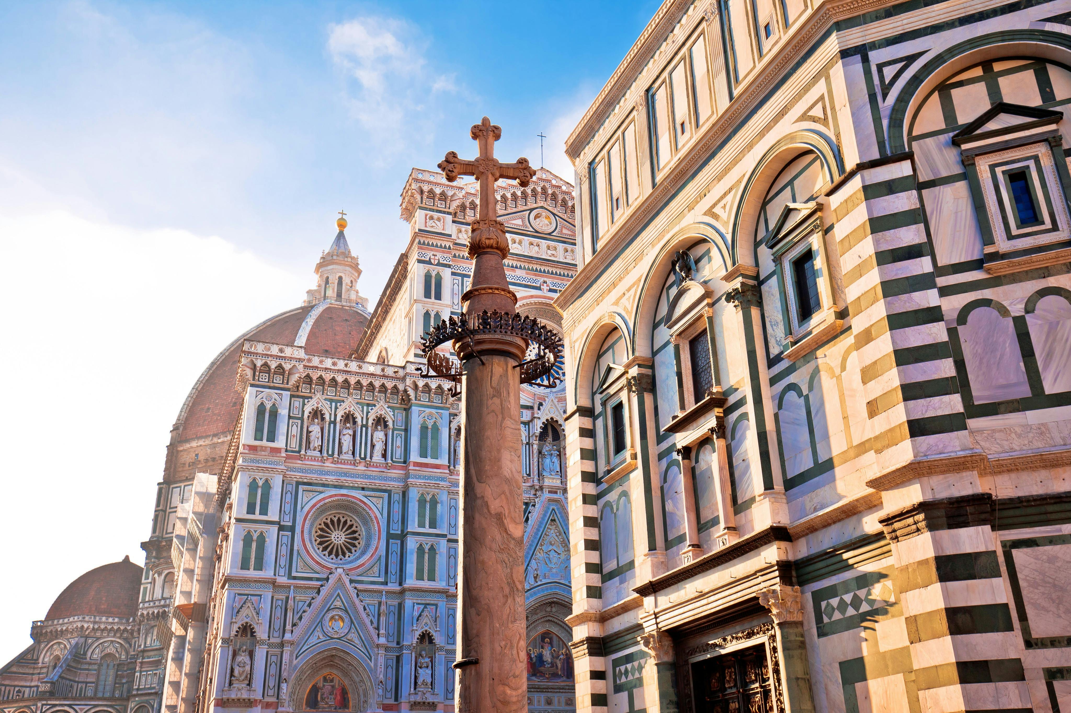 複雑なファサード、大きなドーム、前景に十字架がある華やかな柱、澄んだ青い空を持つ歴史的な大聖堂。