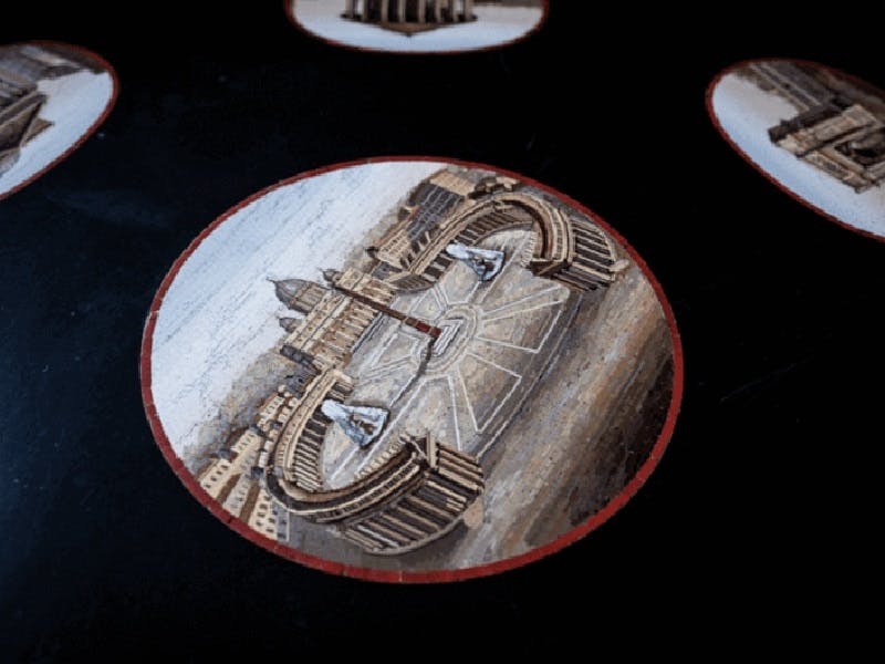 Circular image depicting a detailed illustration of a large plaza with columns, buildings, and statues, viewed from an elevated angle.