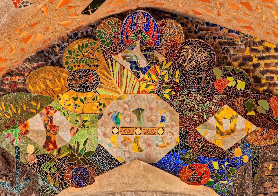 Colorful mosaic with abstract patterns, including geometric shapes and organic forms, in shades of yellow, green, blue, and red.