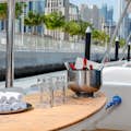 napoje, szklanki, ręczniki do rąk umieszczone na stole na górnym pokładzie jachtu