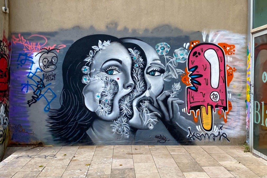 Pouliční umělecké dílo zobrazující 2 ženy a zmrzlinu.