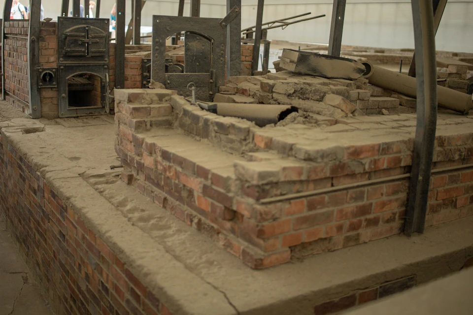 A damaged brick structure with metal equipment, appearing as a historical industrial site or furnace remains.