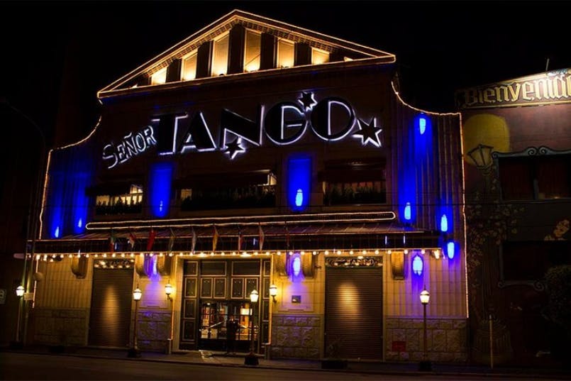 Illuminated building at night with a sign reading "Señor Tango" in large letters and blue lights on the facade.