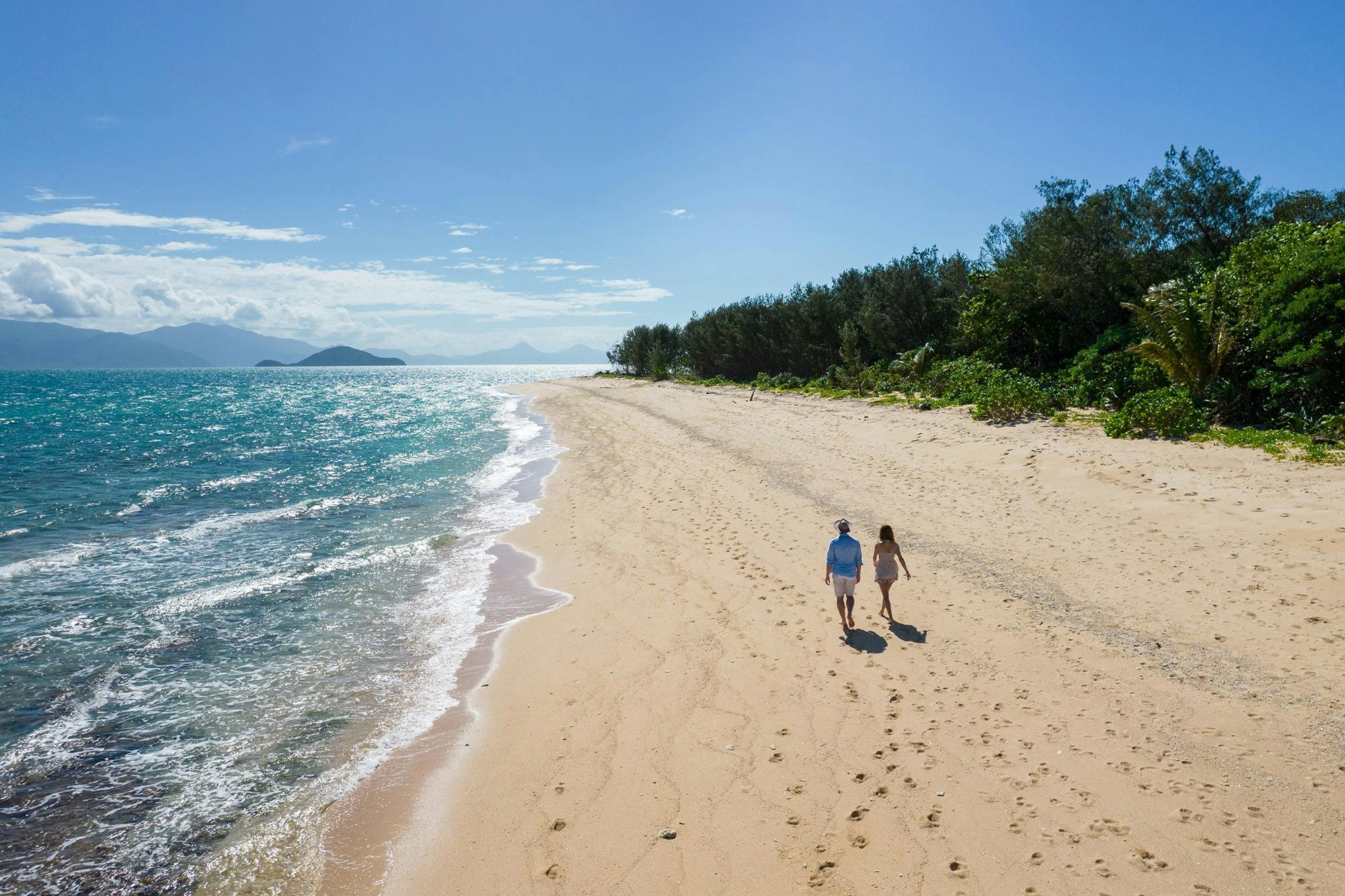 Couple walking along Normanby Island