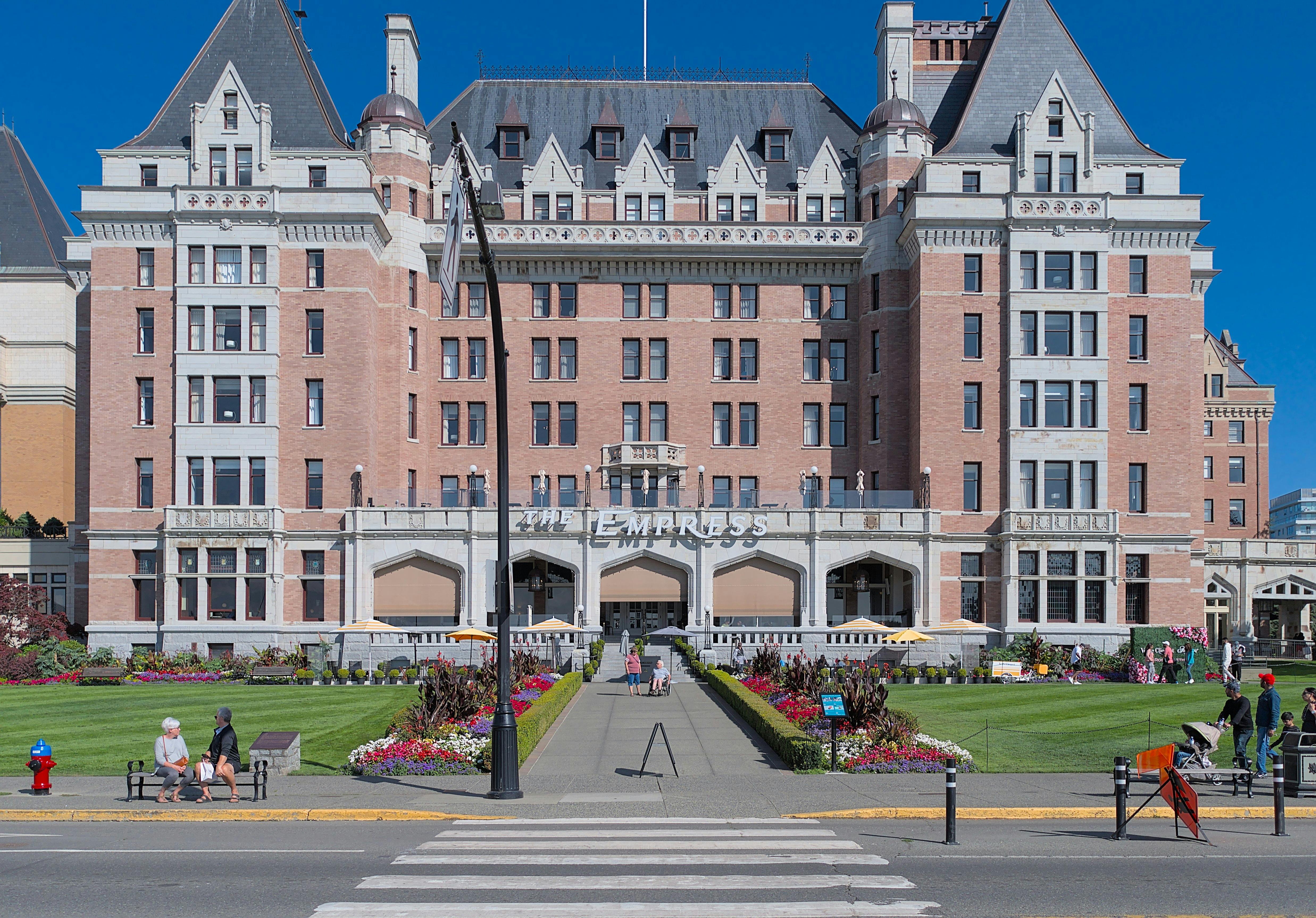 Μπροστινή όψη ενός μεγάλου, ιστορικού ξενοδοχείου από τούβλα που ονομάζεται «Η Αυτοκράτειρα» με περιποιημένους κήπους και πεζόδρομο που οδηγεί στην είσοδο.