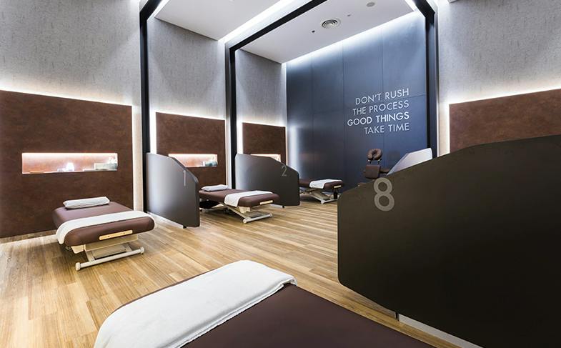 A modern relaxation lounge with reclining chairs, partition walls, and motivational text on the back wall.