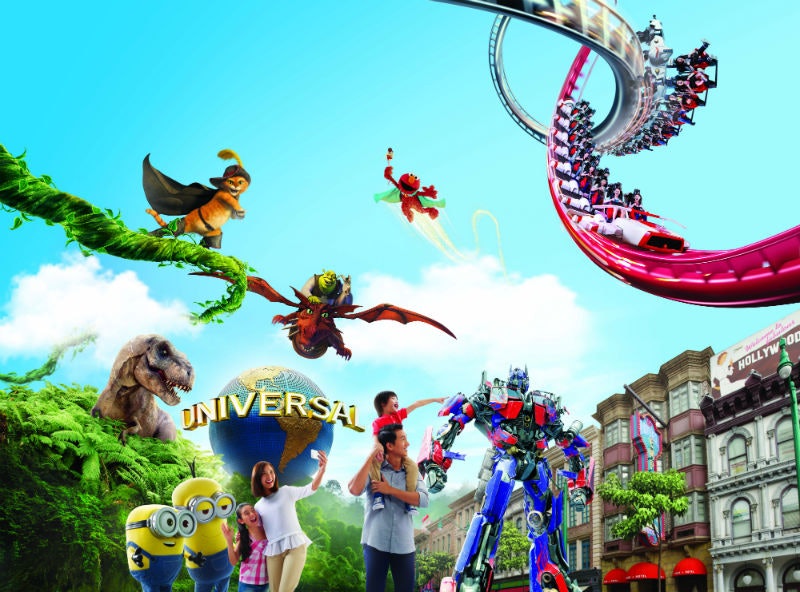 Eine Familie genießt einen Freizeitpark mit animierten Figuren, einer Achterbahn und dem Universal-Globus im Hintergrund.