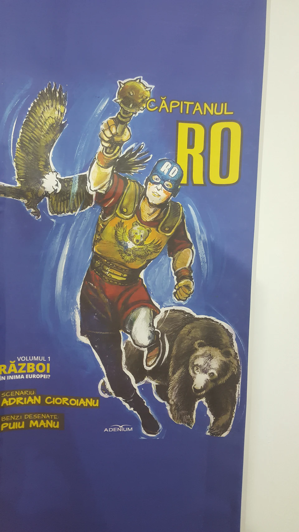 A comic book cover featuring a superhero with "RO" on his helmet, an eagle, and a bear, with a blue background.