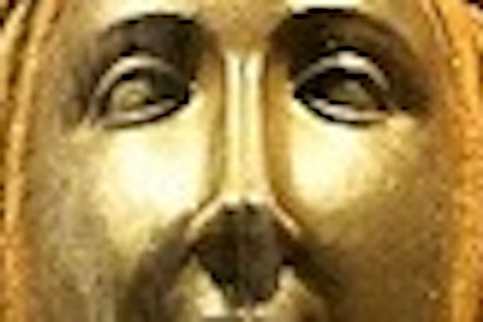 Golden statue of a woman and child seated, surrounded by ornate gold carvings depicting religious figures and scenes.