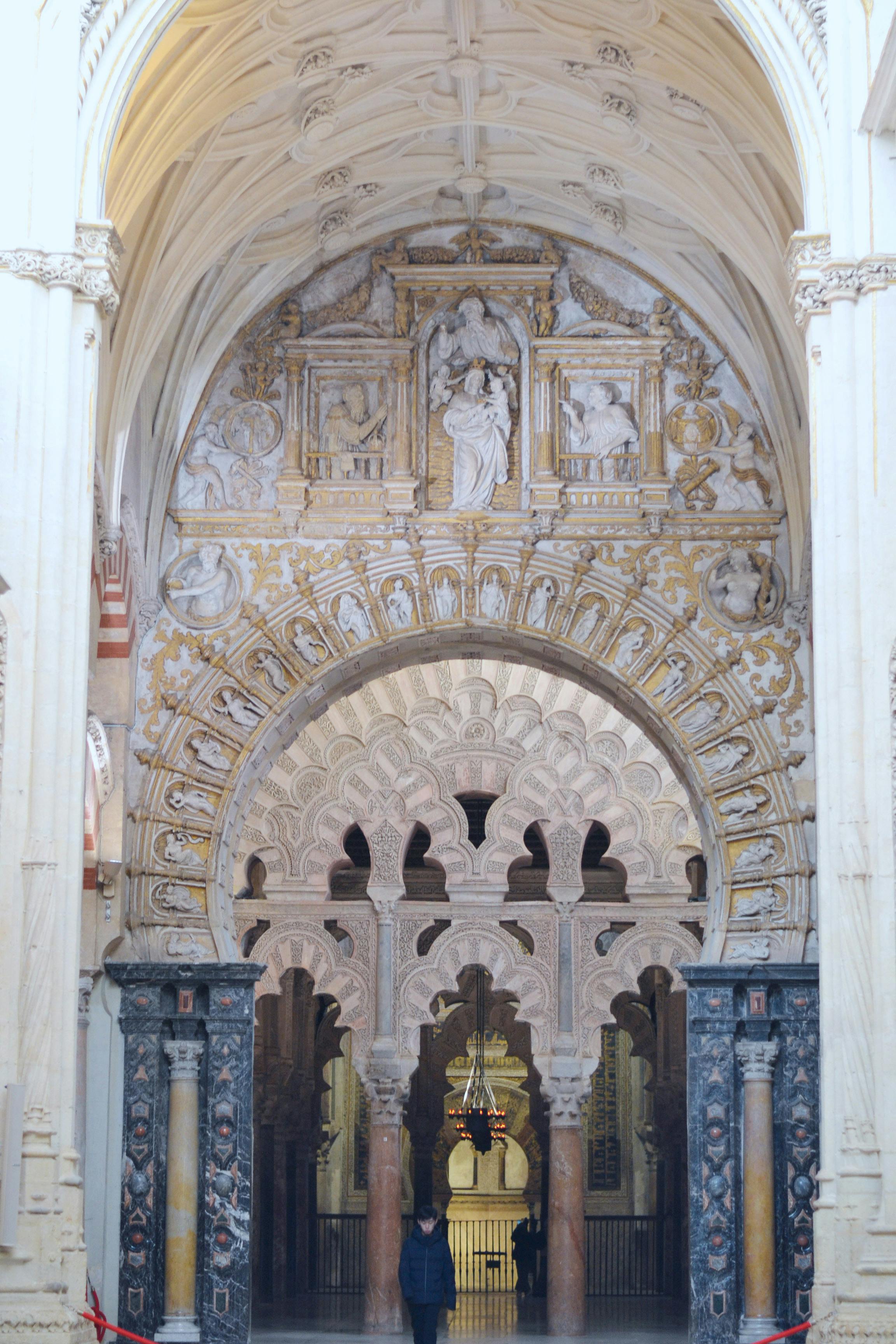 Ornate arched entrance with intricate carvings and marble columns in a historic building.