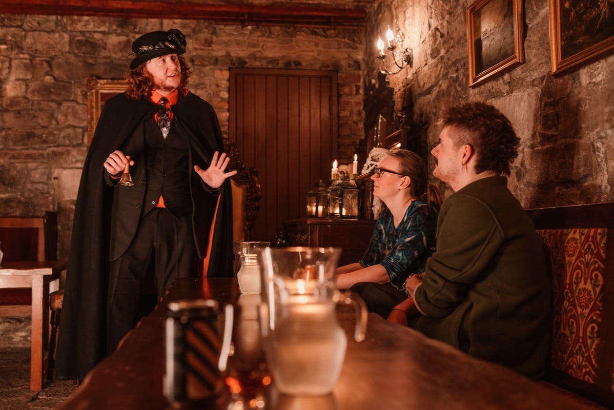 A storyteller shares stories with visitors over a drink in Meggets Cellar.