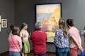 Guia e grupo examinando uma obra de Seurat