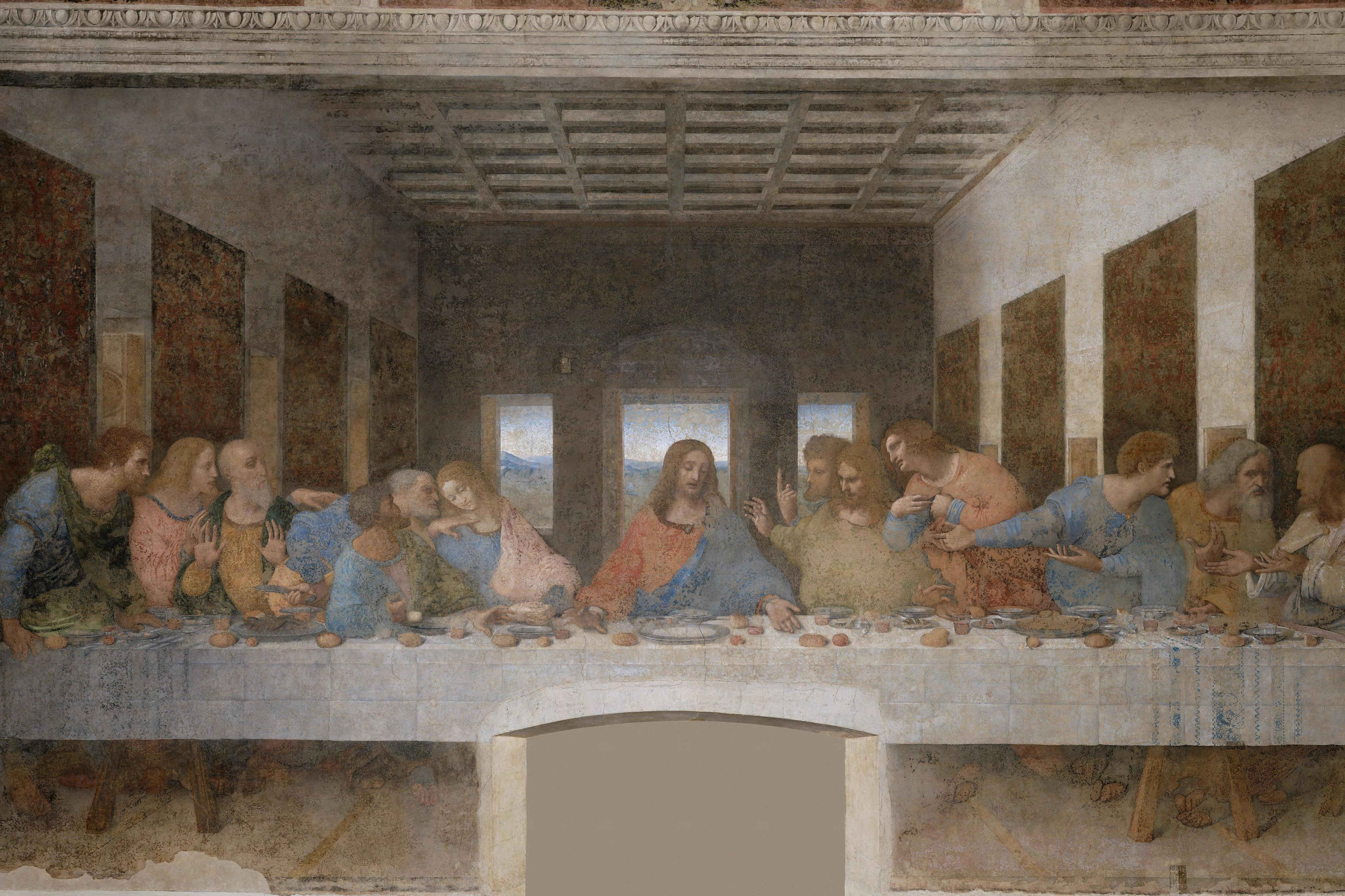 A painting depicts a group of people seated at a long table, with one central figure surrounded by others in a large room.