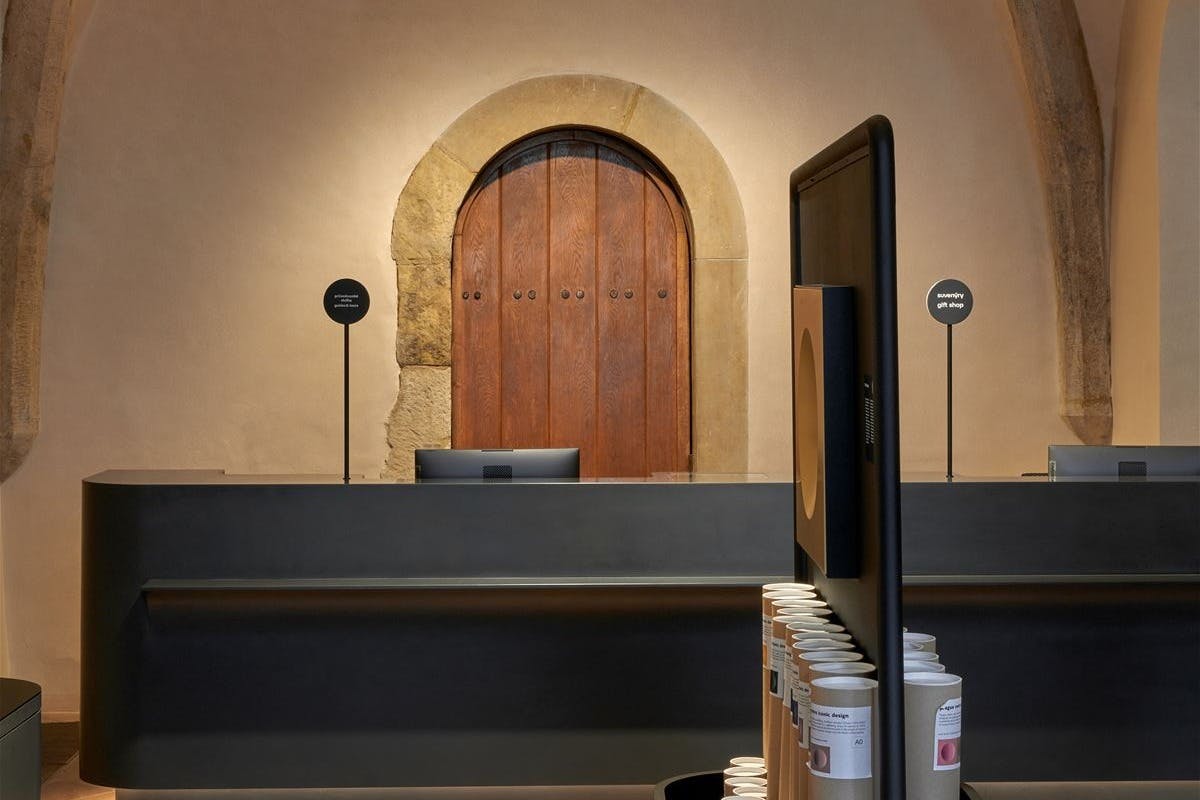 A neatly organized store counter with a wooden door behind it and shelves with products in the foreground.