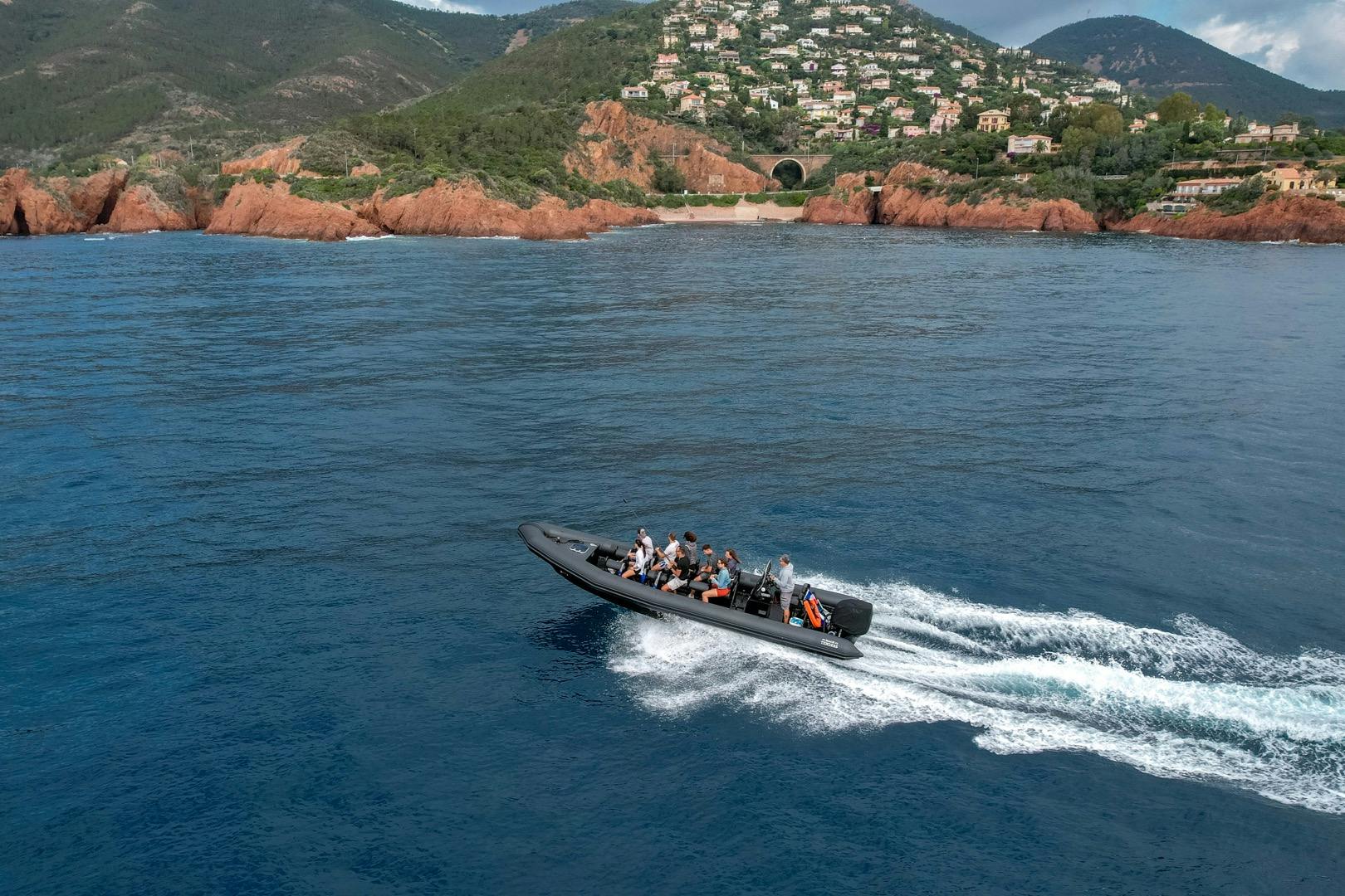 해안가 언덕 마을을 배경으로 푸른 바다 위로 사람들이 타고 있는 스피드보트가 재빠르게 움직입니다.