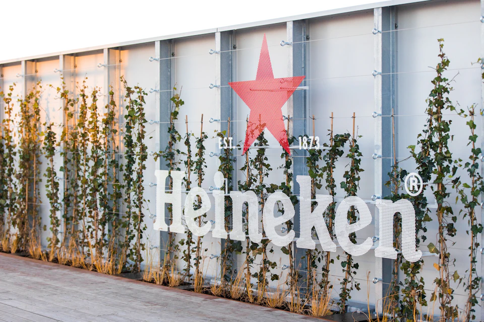 A wall covered in green vines, the Heineken logo featuring a red star, and the text ‘Est. 1873’ displayed prominently.