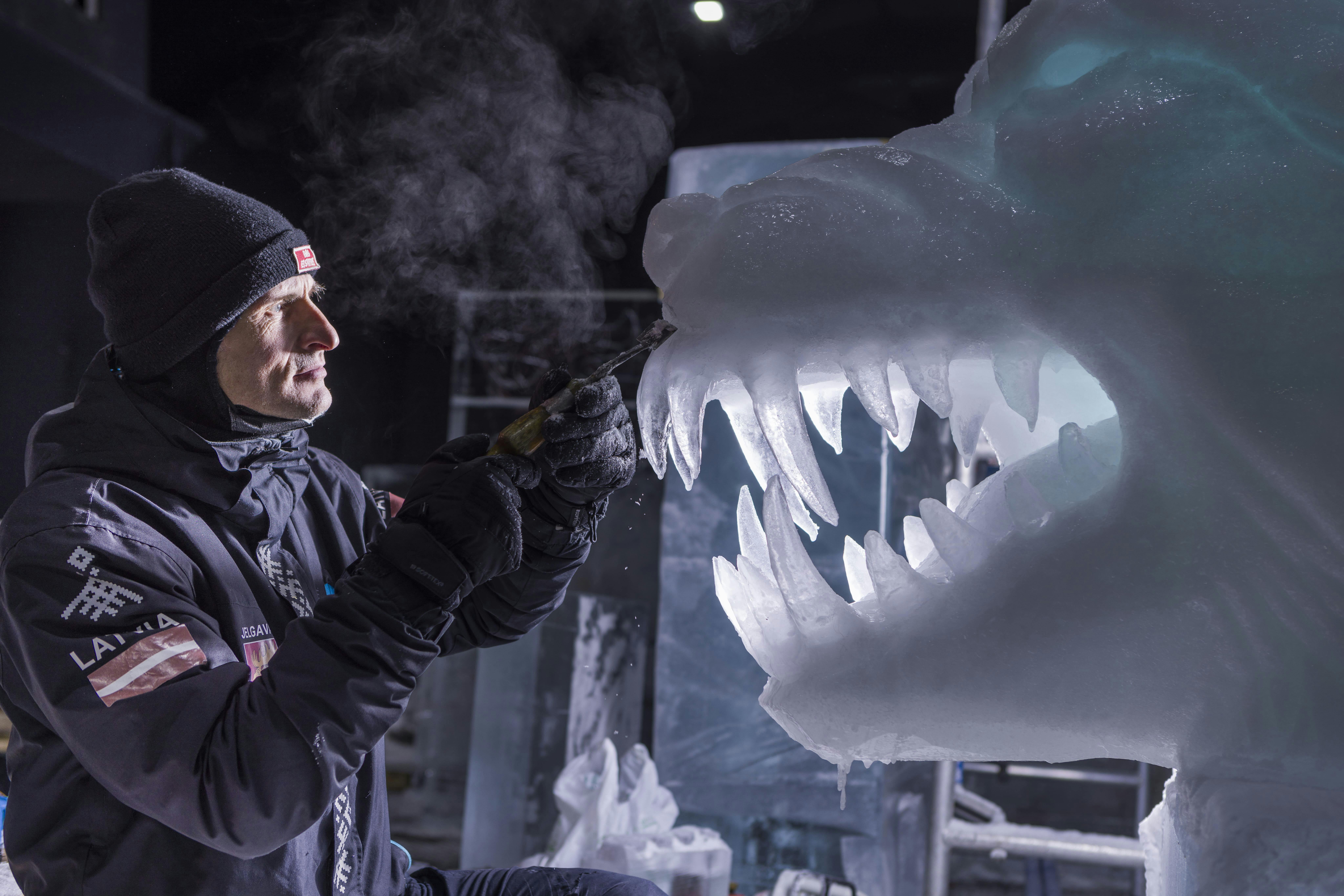 Eisskulpturen einer eingewickelten Mumie, eines leeren Sarkophags und eines ägyptischen Pharaos, beleuchtet mit roter und blauer Umgebungsbeleuchtung.