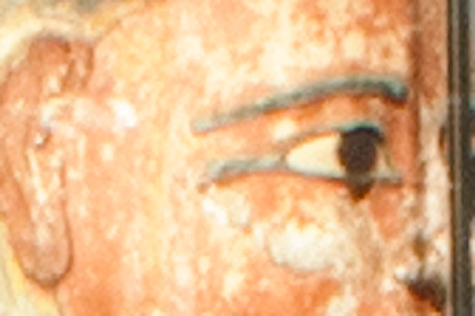 Museum exhibit featuring an ancient Egyptian sarcophagus, artifacts in glass cases, and informational panels. Visitors observing displays.