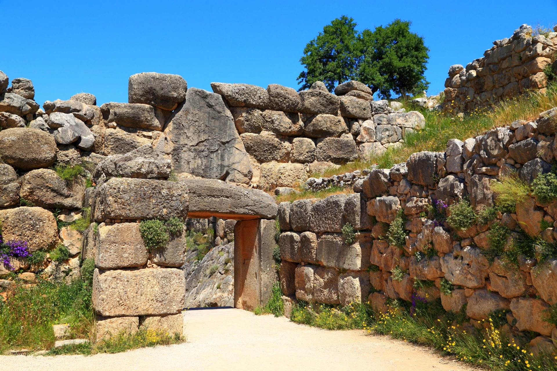 The famous Lion Gate of Mycenae, an ancient stone entrance framed by massive Cyclopean walls.