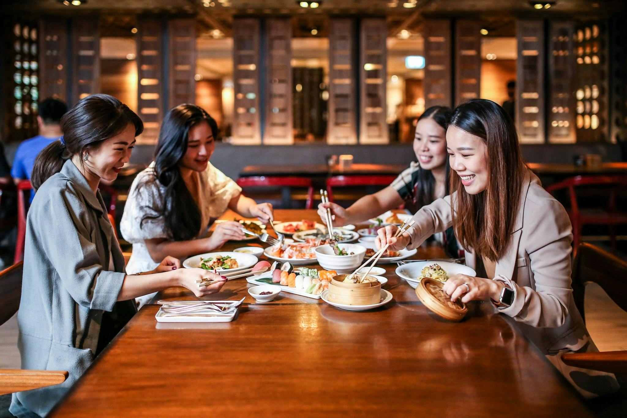 A group of people enjoying a meal together at a restaurant, with various dishes on the table and a warm ambiance.