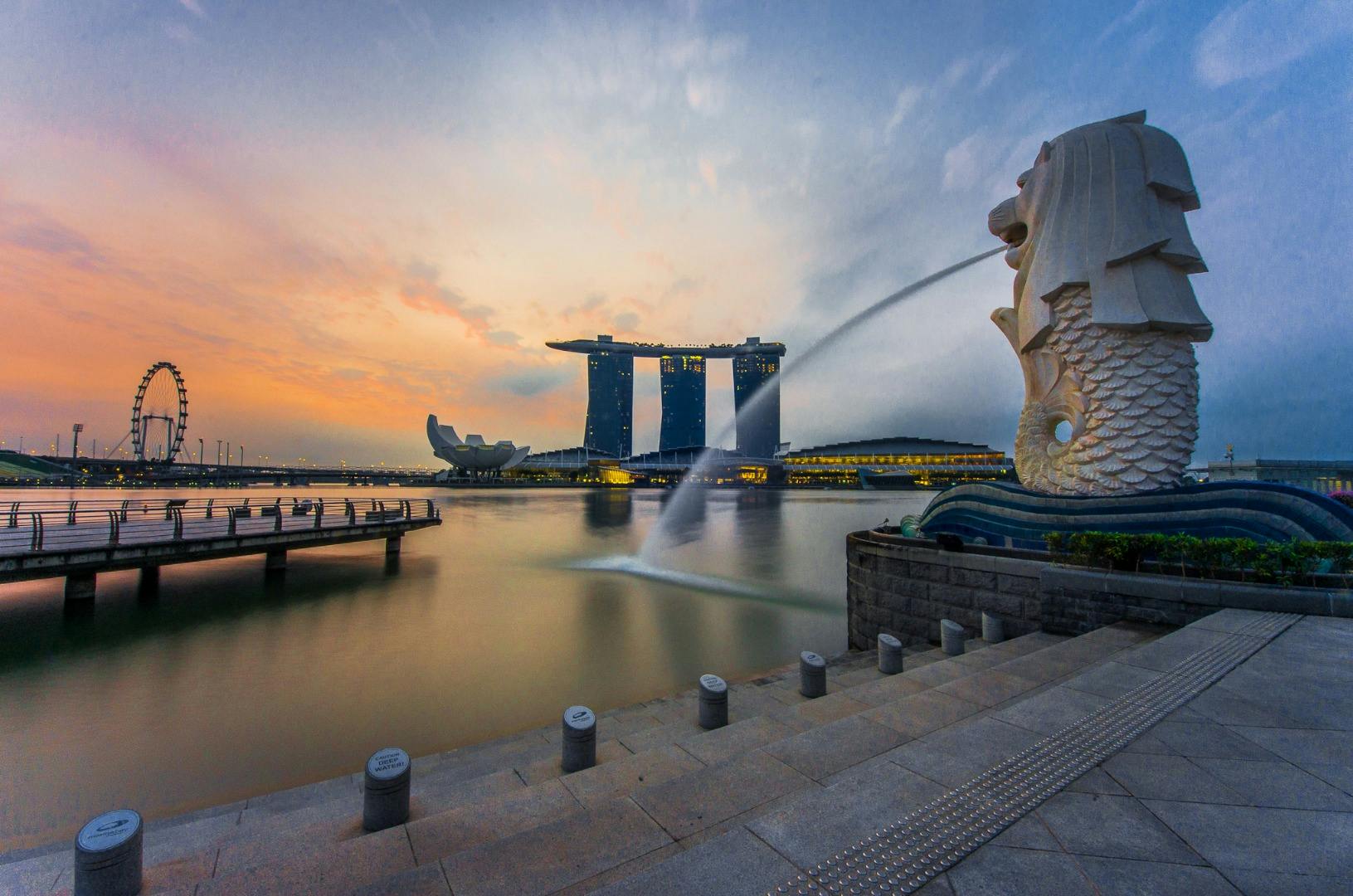 Pejzaż miejski z posągiem Merliona, Marina Bay Sands, ArtScience Museum i Singapore Flyer o zachodzie słońca.