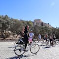 Un groupe de cyclistes et une jeune fille enthousiaste sur un vélo électrique sous la colline de l'Acropole.