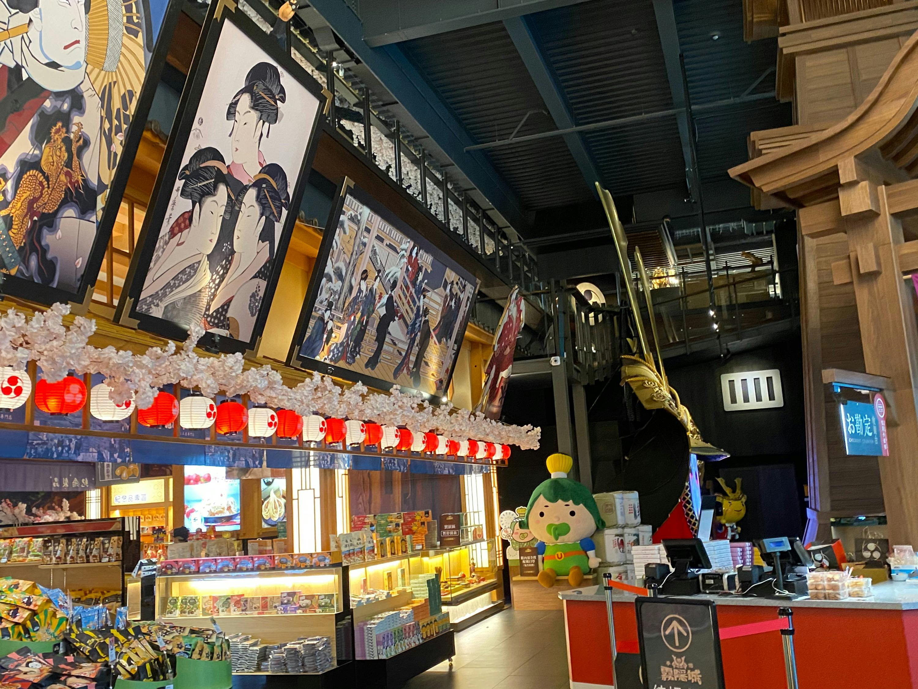 A colorful store interior with Japanese-themed decorations, including lanterns, artwork, and a ship display.
