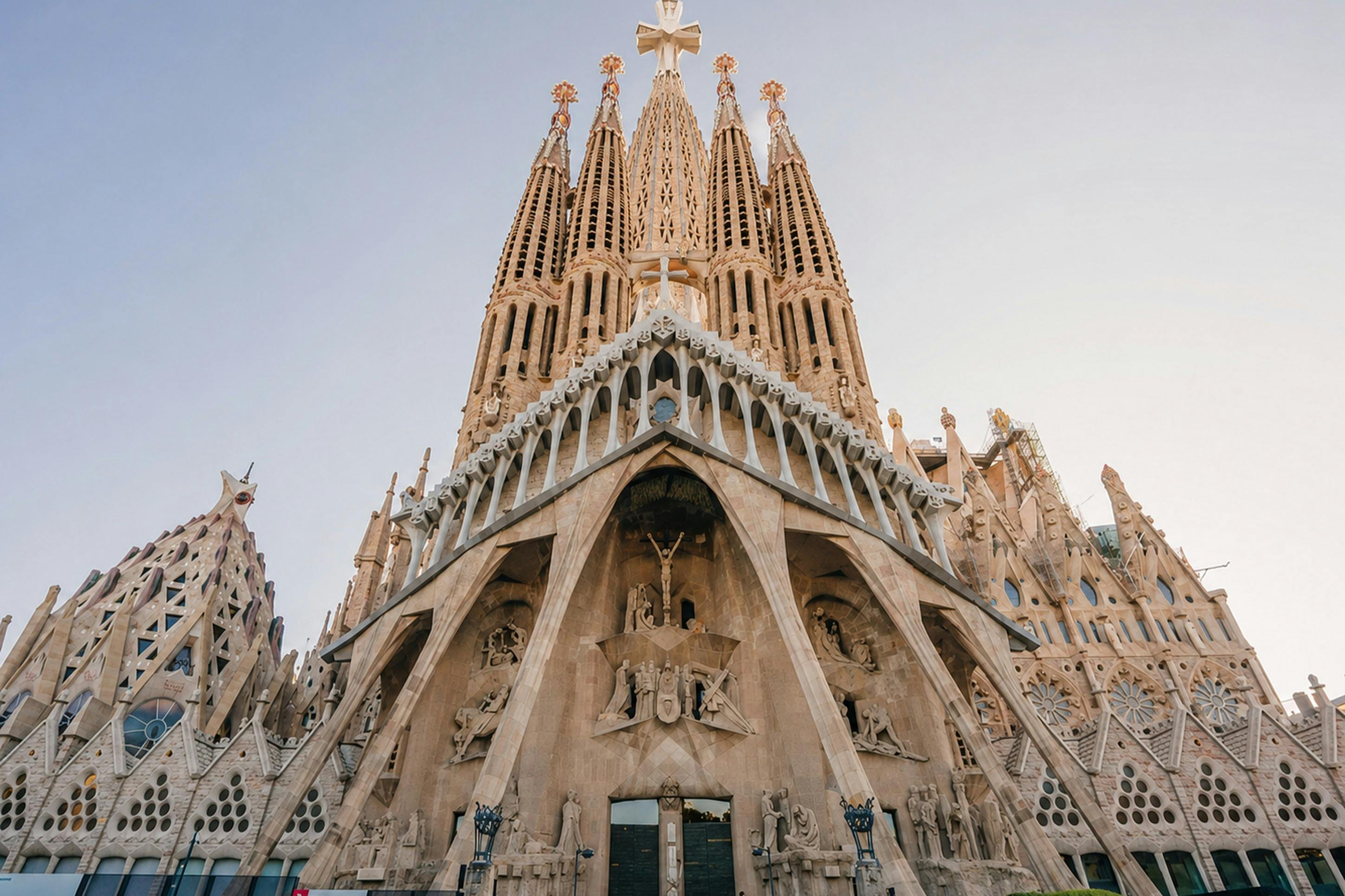 The ornate facade of a large cathedral with tall spires and intricate carvings against a clear sky.