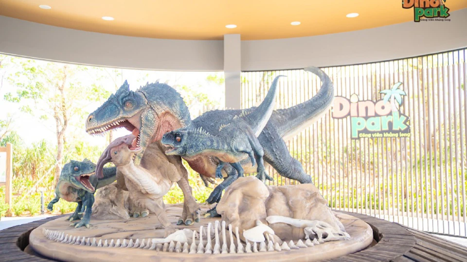 Dinosaur sculptures in a museum display, featuring detailed models of large theropods in a dynamic pose.