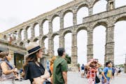 Turist framför akvedukten i Segovia