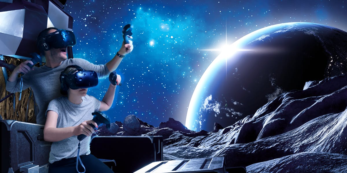 Twee mensen met VR-headsets op en controllers in de hand, ondergedompeld in een simulatie met een ruimtethema met sterren, een planeet en rotsachtig terrein.