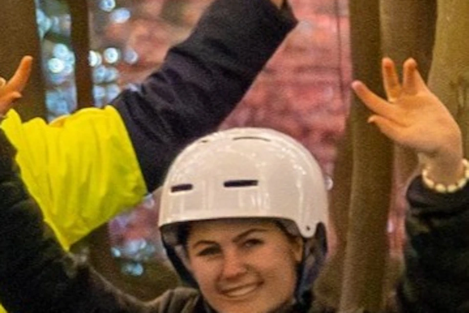 People riding Segways under a canopy of trees decorated with string lights, surrounded by lush greenery at night.