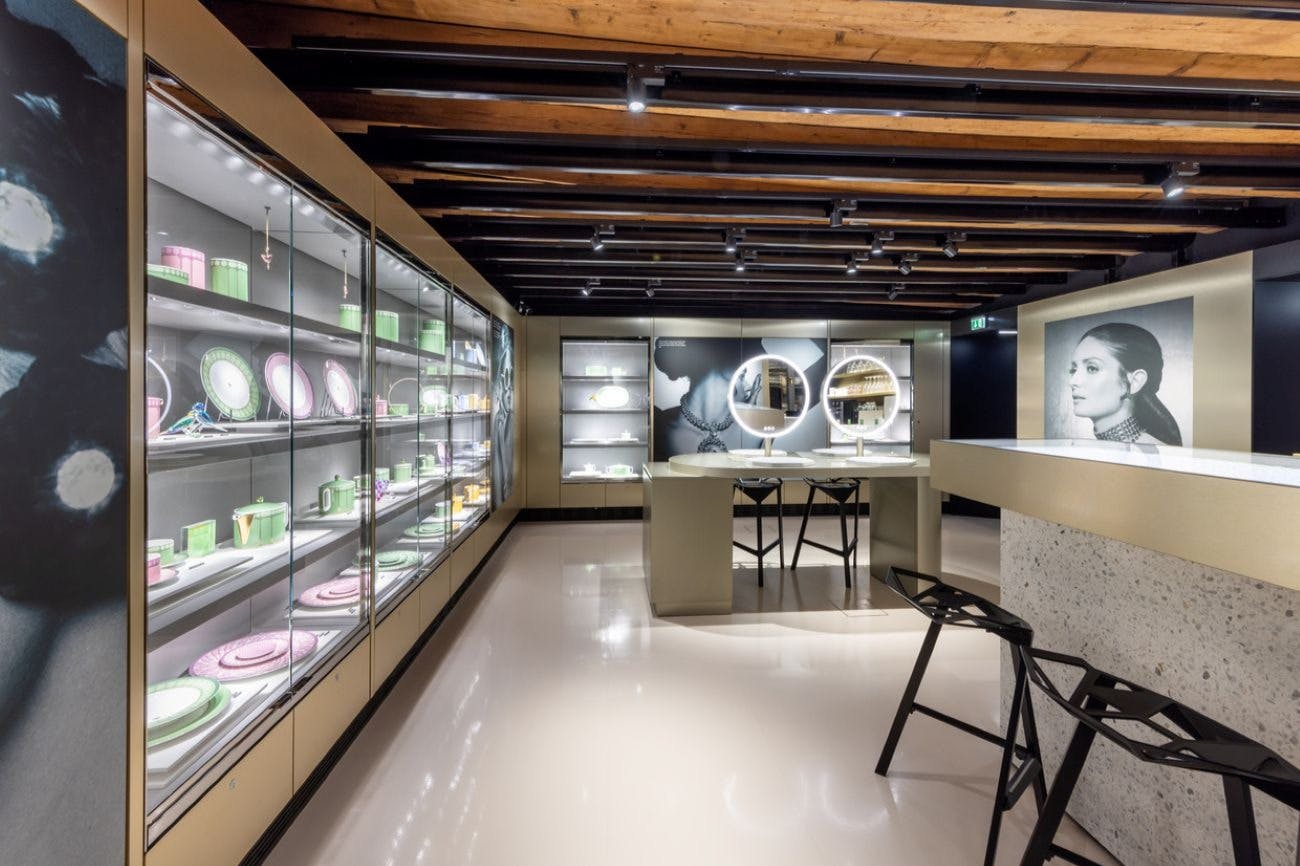 现代化的零售商店，配有木制天花板、黑色凳子、镜子和大型黑白女性肖像。