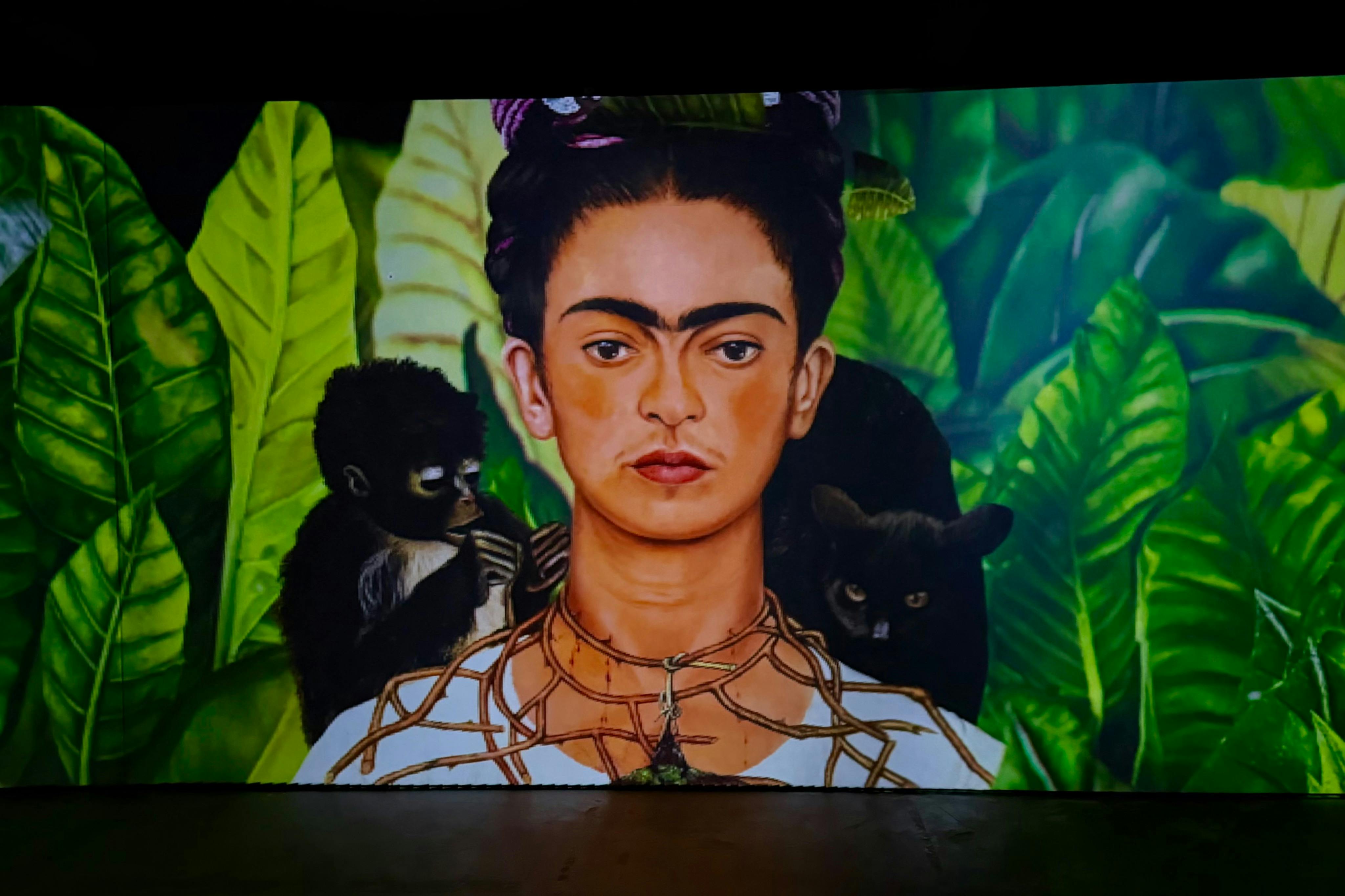 肩に猿と黒い動物を乗せた緑の葉の前にいる人物の絵。