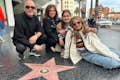 Un turista de la zona del Paseo de la Fama de Hollywood está feliz con su propia réplica de la estrella personalizada para una foto.#grupo