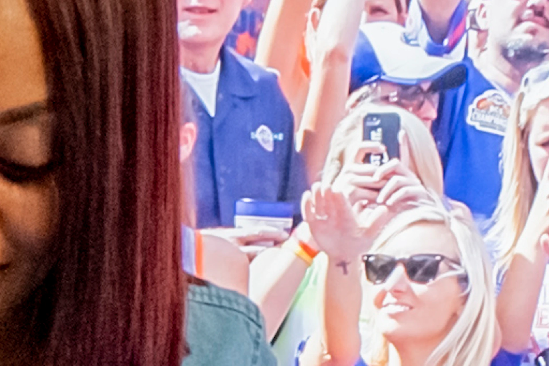 A woman interacts with a digital display of a football field, with large sports-themed images on the wall behind her.