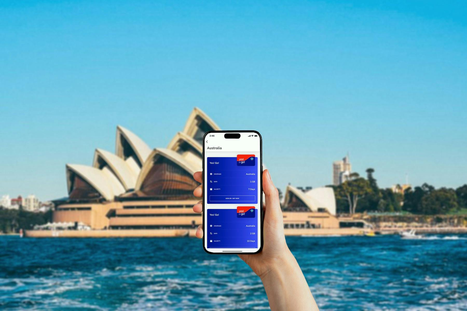 Una mano che tiene in mano uno smartphone con un'applicazione per il piano dati visualizzata di fronte all'Opera House di Sydney in un cielo azzurro e limpido.