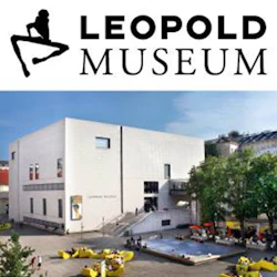 Vit modern byggnad av Leopold Museum, uteservering, en fontän och träd som omger en torg under klar himmel.