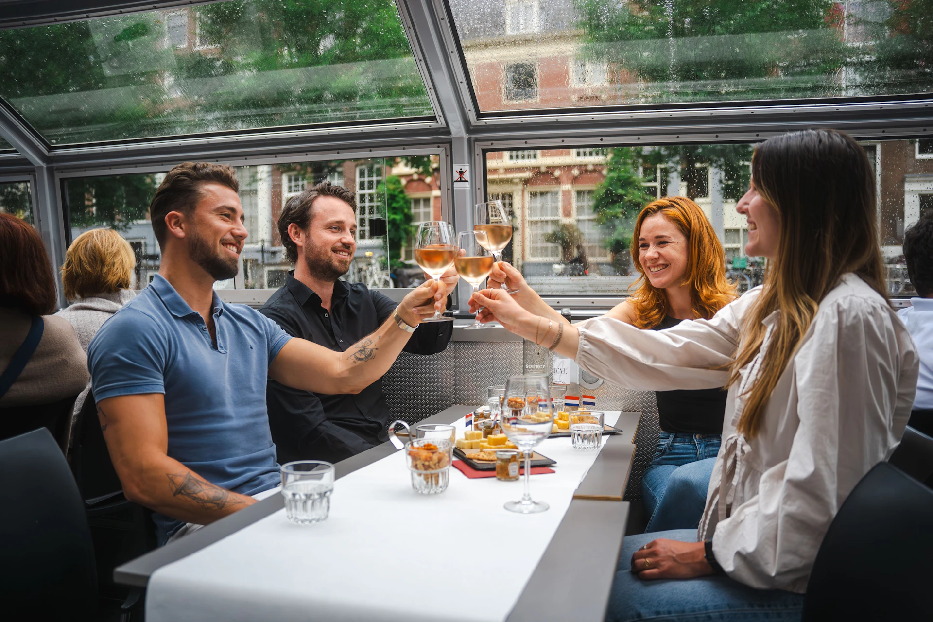 A group of friends enjoys a boat tour with cheese and wine
