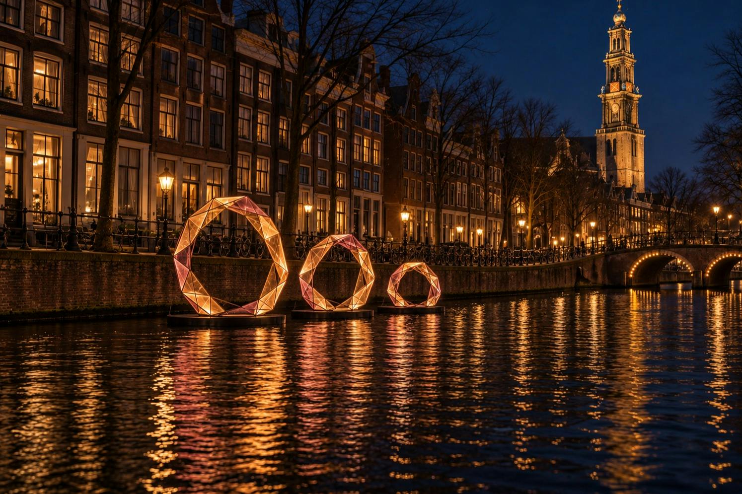 Una vista notturna di un canale con sculture geometriche illuminate sull’acqua e edifici illuminati lungo la riva.