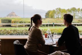 Um casal admirando a suntuosa vista da abadia enquanto almoça