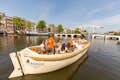 Croisière sur les canaux avec guide en direct sur un canal d'Amsterdam entre les péniches.
