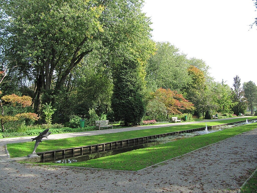 这座公园维护良好，有树木、长凳、绿色草坪、步行道和带有小喷泉的狭窄运河。