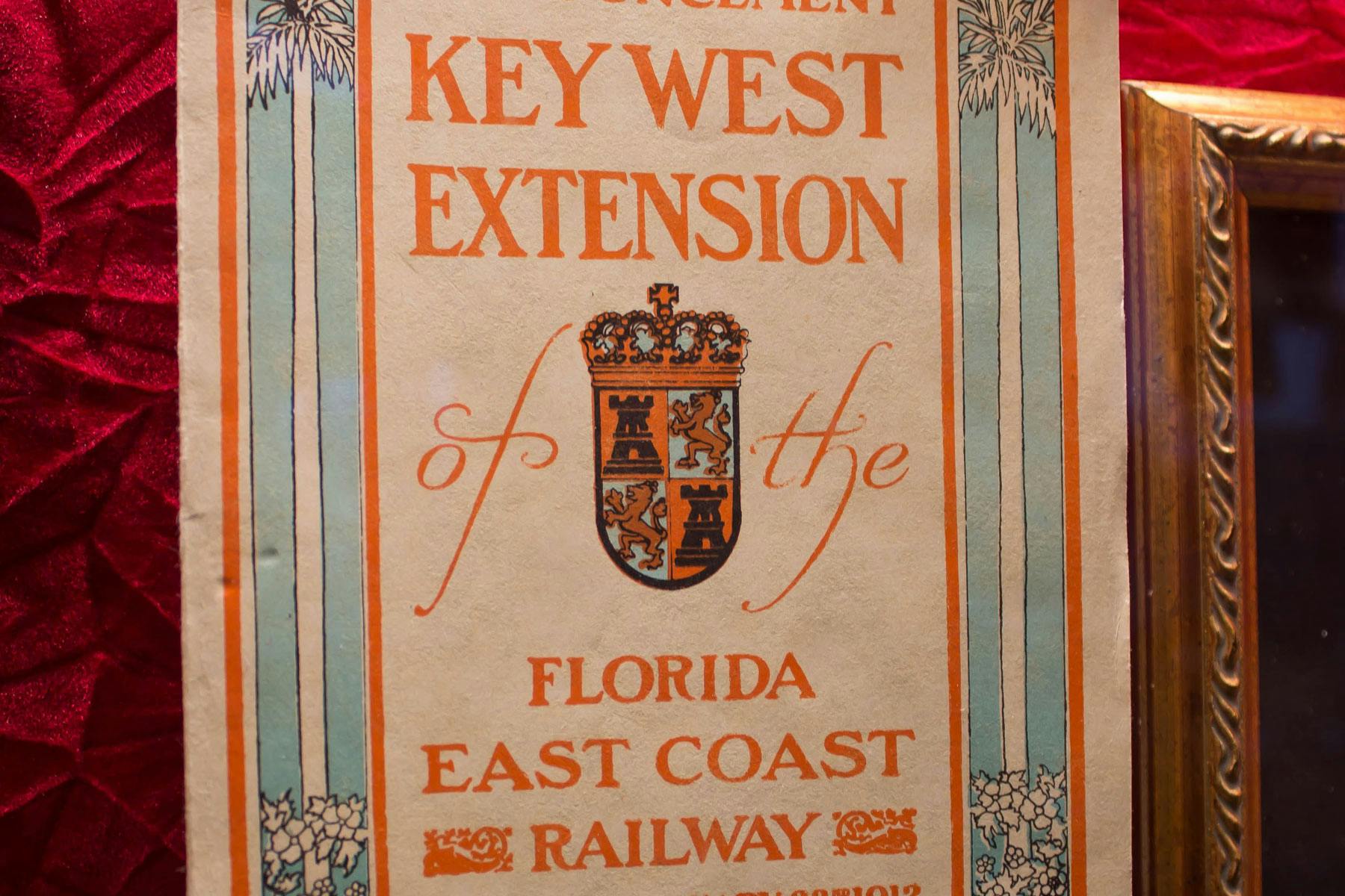 Vintage-affisch för Key West-förlängningen av Florida East Coast Railway med dekorativa kolumner och ett krön.