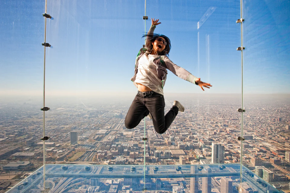 Woman jumping on ledge at Skydeck in chicago