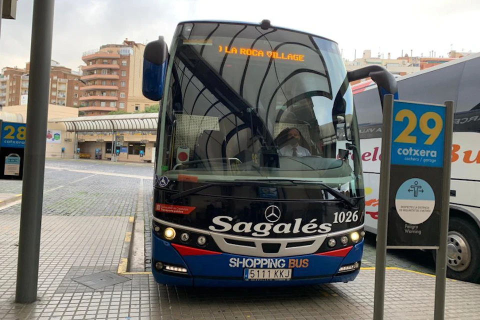 Front view of a blue and black bus with "Sagales" and "SHOPPING BUS" on the front, displayed at a bus station.