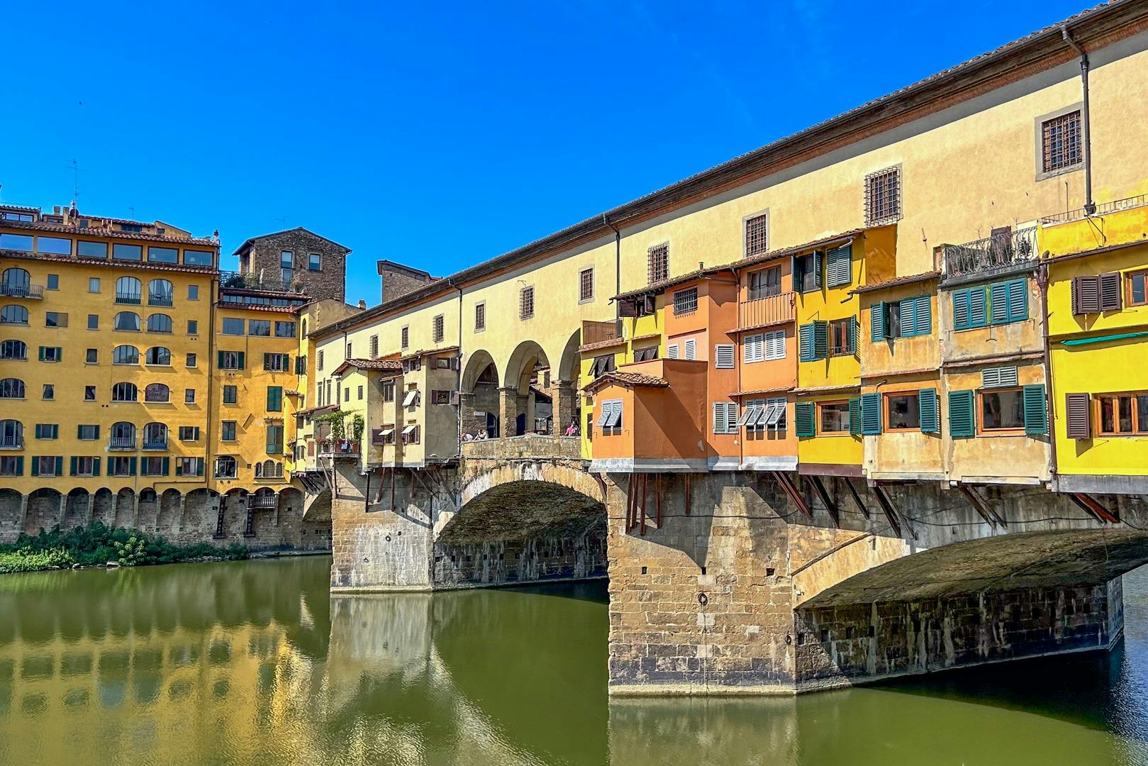 这座历史悠久的桥梁拥有五彩缤纷的建筑，在晴朗的蓝天下横跨