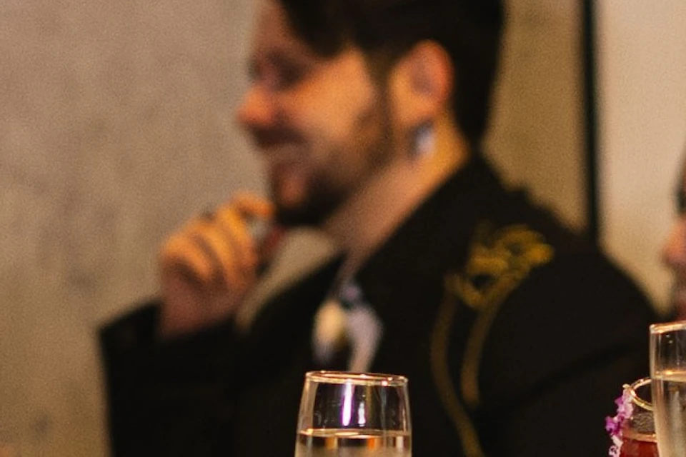 People seated at a dining table in a restaurant, raising glasses in a toast, with a "starline cruises" sign visible.