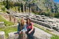 Gasten op de foto met de archeologische site van Delphi op de achtergrond